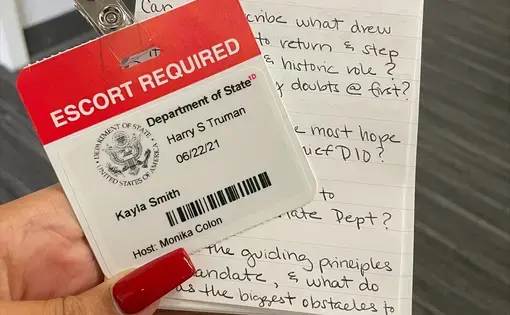 notebook and badge in hand