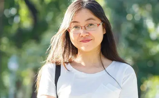 A person wears glasses and a white shirt.
