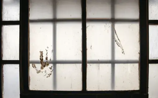 Hand print through jail cell