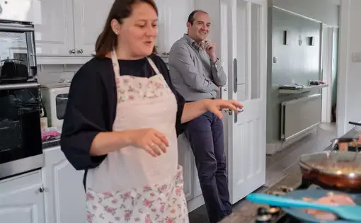 a woman stands in her kitchen