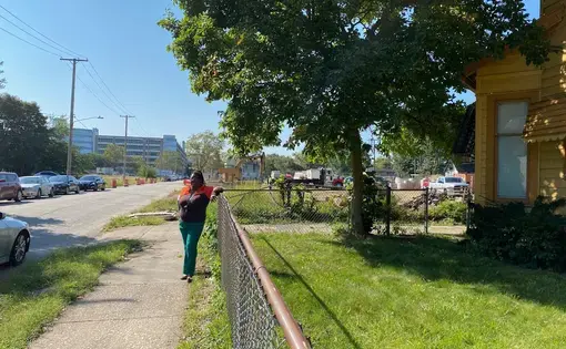 woman stands in front of house