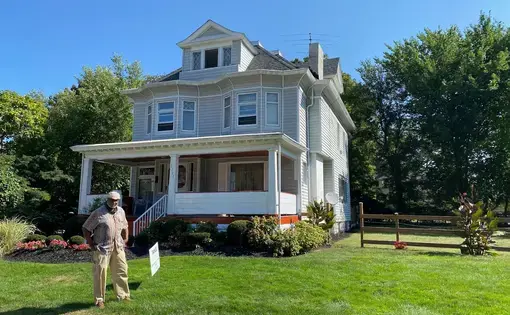 man standing in front of house