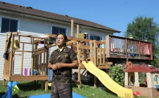 man stands in front of house