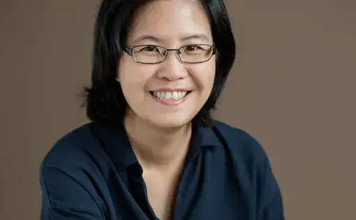 Image of a person wearing glasses and a dark blue shirt.