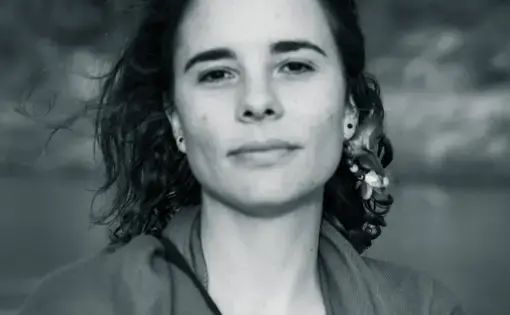 Image of a person wearing a jacket and a blouse.