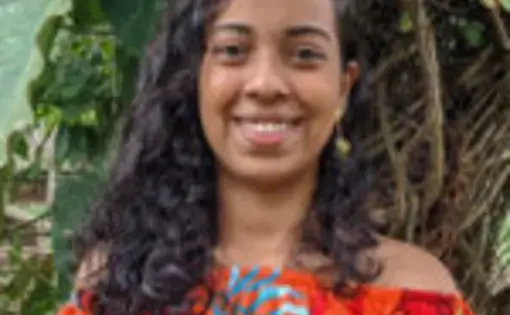 A person wears a bright red shirt with feathers.