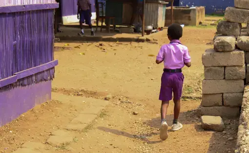 Young boy walks down a road