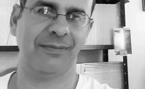 A person wears a shirt and glasses.