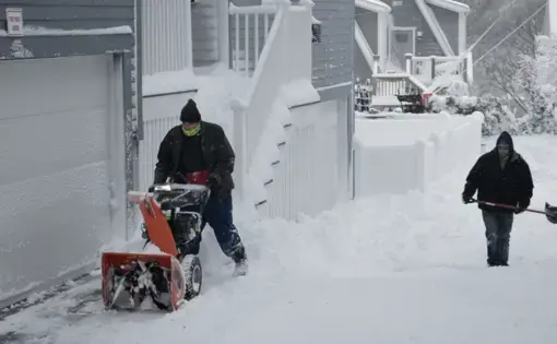 two people plowing snow