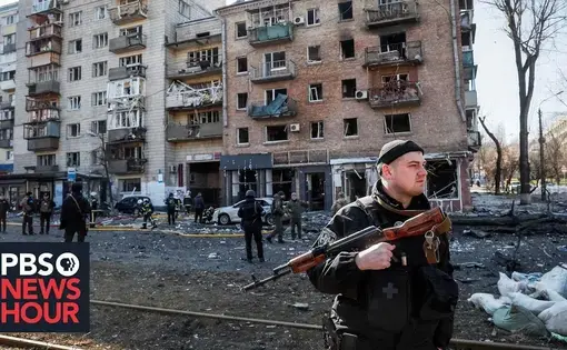a man stands in front of a crumbling building