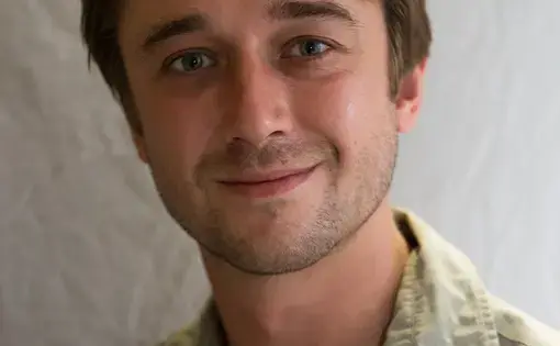 A person wears a green work shirt with buttons.
