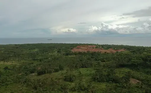 An aerial overview of mines next to a forest in the Philippines.
