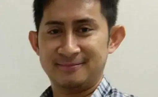 A person wears a blue jacket and black shirt.
