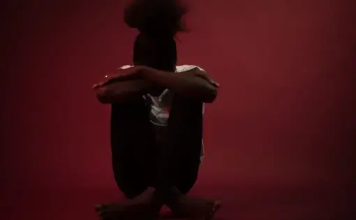 woman seated in shadows