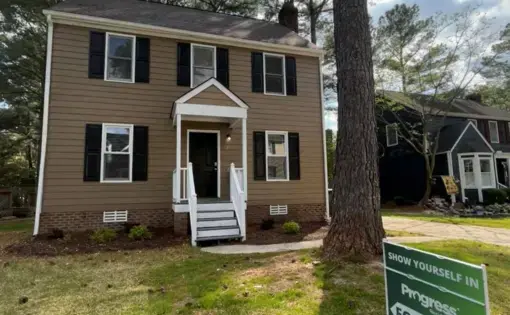 a 'for rent' sign hangs in the grassy yard of a two story home