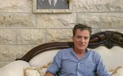 Elias Jarade poses on his living room couch