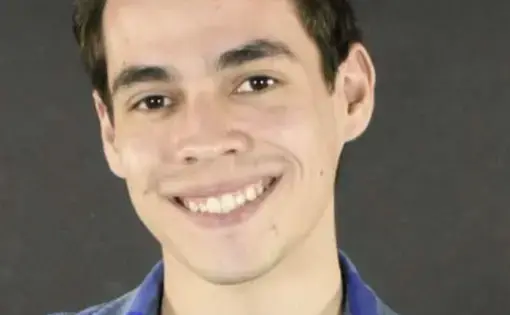 A person with short hair and wears a blue flannel shirt.