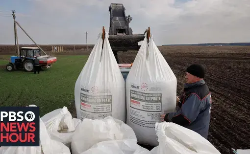 a tractor picks up two large bags labeled ammonium sulphate