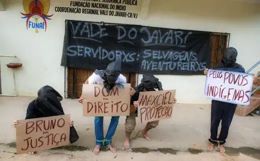 4 men covered in fabric protest with signs