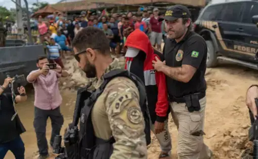 a man is being escorted by a police officer.