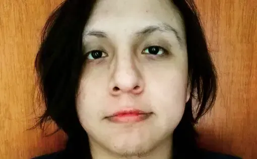 A person with black long hair and a black shirt.
