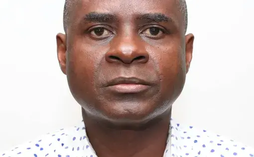 A person wearing a white patterned shirt.