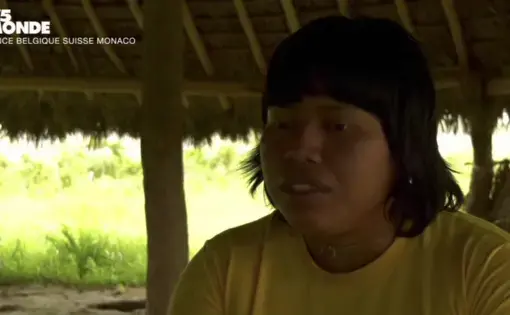 An Indigenous woman speaks to a television reporting crew in Brazil.