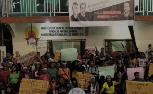 A crowd of Indigenous activists gather in a rally outside of a government office in Brazil.