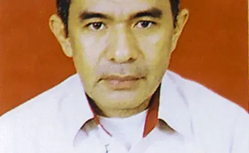 A person with short black hair and a white work shirt.