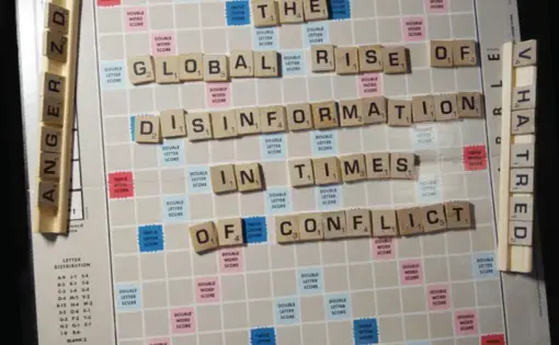A scrabble board reads, "The Global Rise of Disinformation in Times of Conflict."