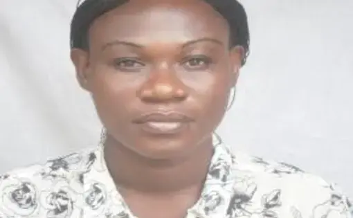 A woman wears a white floral-patterned shirt.