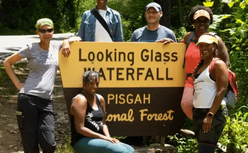 a group takes a photo in front of a national park sign