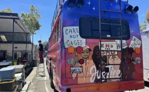 Picketers, speaking out against solitary confinement, painted on a retro-fitted schoolbus.