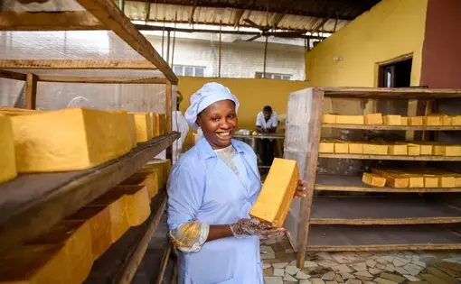 Woman holds loaf of sweet potato bread.