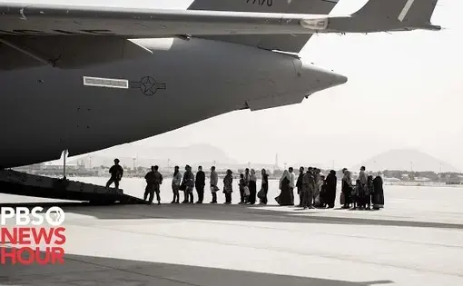 People board a plane. Thumbnail from "Afghans who fled their homes during the chaotic U.S. withdrawal reflect on the last year" video.