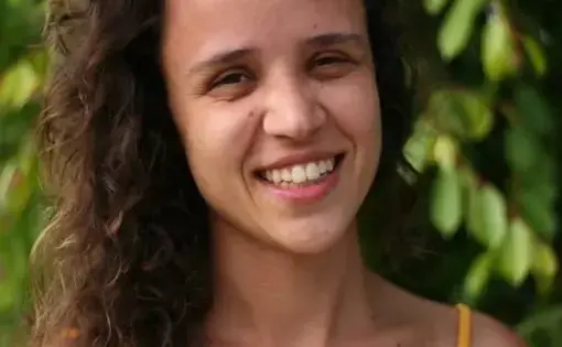 A WOMAN SMILES INTO THE CAMERA