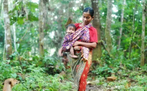 Mother Nidar carries her baby to the child bathing ritual in the Orang Rimba community in Bukit Duabelas National Park, Sarolangun, Jambi, Saturday (2/7/2022).