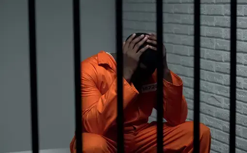A prison inmate wears an orange jumpsuit.