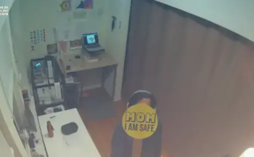 Livestream screenshot of an apartment with a sticker that reads "Mom I am safe"