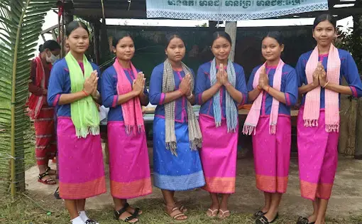 A group of young women who are Kuy Indigenous Peoples stand in a row smiling for the camera