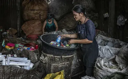 A woman sorts plastics