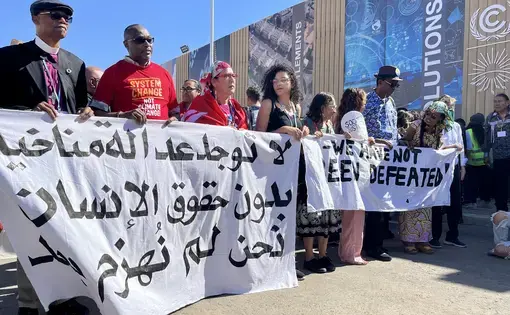 protestors hold banners saying "we have not been defeated"