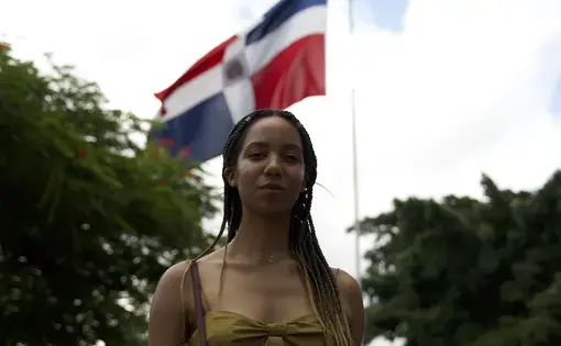 Natalia Perez-Gonzalez stands in front of the Dominican flag
