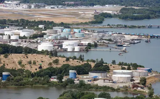 Aerial view of oil sludge cylinders next to water