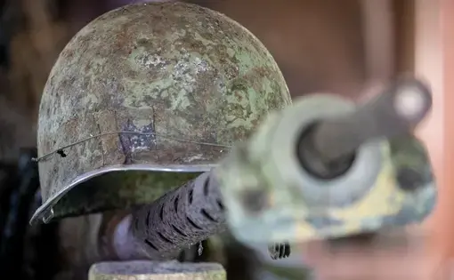 A helmet and gun, rusted, from World War Two.