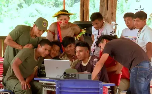 People gather around a computer.