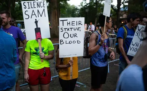 college student protestors hold signs