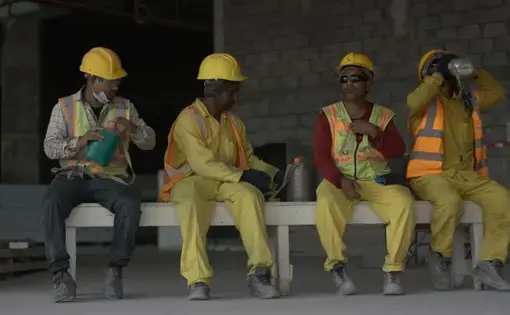 four construction workers sit and drink water
