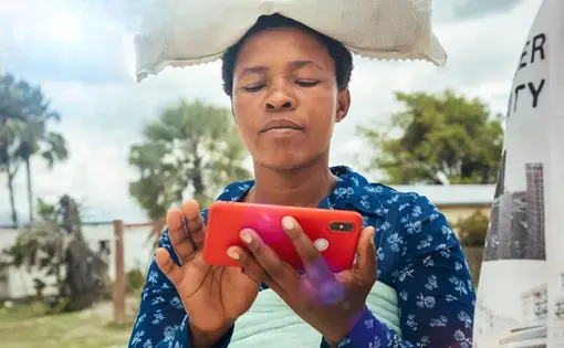 A Kenyan boy looks at his phone