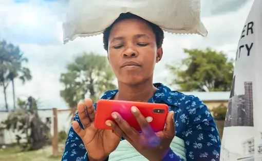 A Kenyan boy looks at his phones